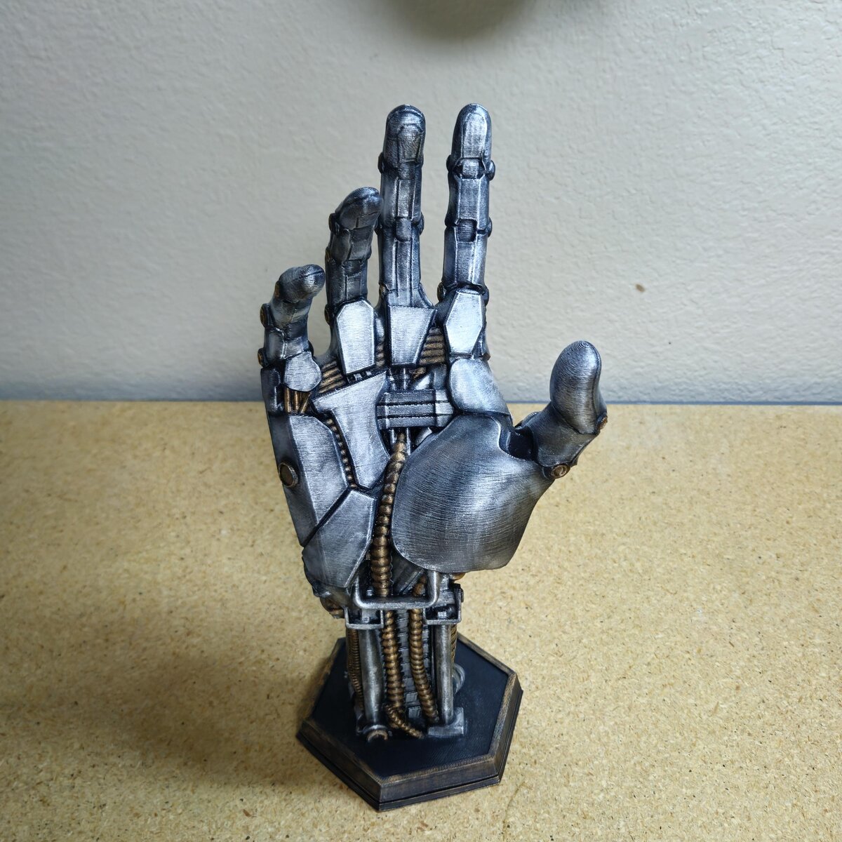 Finished 3D printed cyber-mechanical hand on the workbench